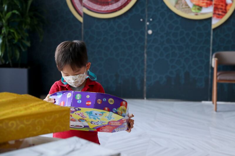 A young boy opens his gift at The Galleria Mall Al Maryah Island. Khushnum Bhandari / The National