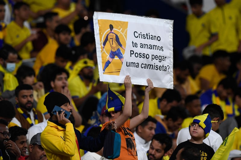 A fan carries a poster asking for the jersey of Cristiano Ronaldo. AFP