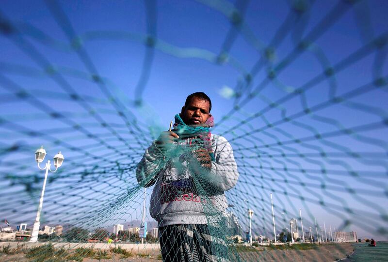 FUJAIRAH, UNITED ARAB EMIRATES, March 3, 2014:   
Bangladeshi fisherman, a hired hand, Kala Miya, 40, works on fixing a torn fishing net at the Al Rughayalat Port on Monday, March 3, 2014. Miya said that there isn't much fish left in the sea and that in the month of February 2014, they barely caught any. When they do get a catch, they share 50 percent of the profit with the boat owner, usually a local Emirati. The boat grew, 16 in this case, split the other half.
(Silvia Razgova / The National)

Section: National
Reporter: Lindsay Caroll
Usage: Undated


 ANNIVERSARY EDITION 