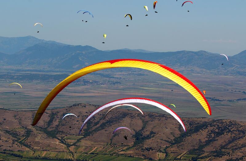 Pilots fly their paragliders during 16th FAI Paragliding World Championship in Krusevo, North Macedonia.  Reuters