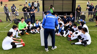 Coach Jeff Hopkins explains tactics to members of the Melbourne Victory Afghan Women’s Team. AFP