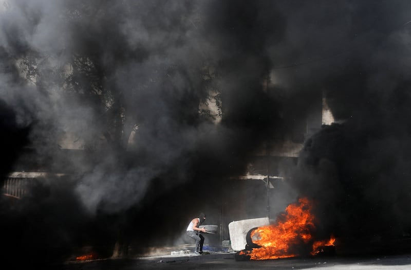 A Palestinian burns tyres at an Israeli army checkpoint during clashes, in Hebron in the Israeli-occupied West Bank. Reuters