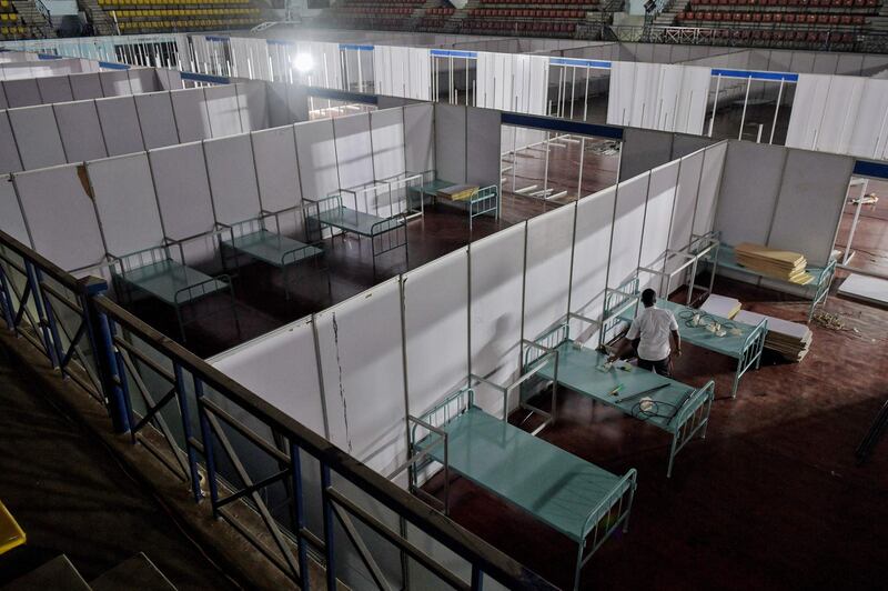 Workers convert the Koramangala indoor stadium into a COVID-19 coronavirus care centre with over 250 beds, in Bangalore. AFP