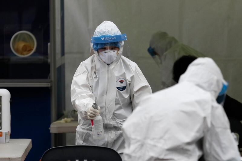 A medical worker wearing protective gears sprays disinfectant at a coronavirus testing site in Seoul, South Korea. AP