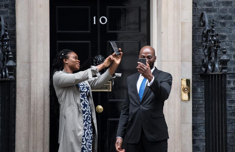 Two visitors take selfies outside number 10 Downing Street in London, England, UK. Chris J Ratcliffe / Getty Images
