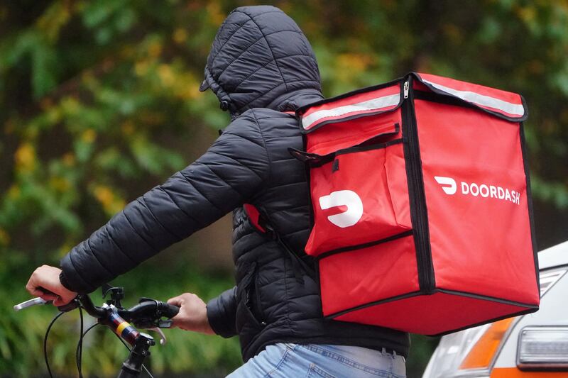 A delivery person for DoorDash, whose co-founders each amassed fortunes of $2.5 billion or more. Reuters