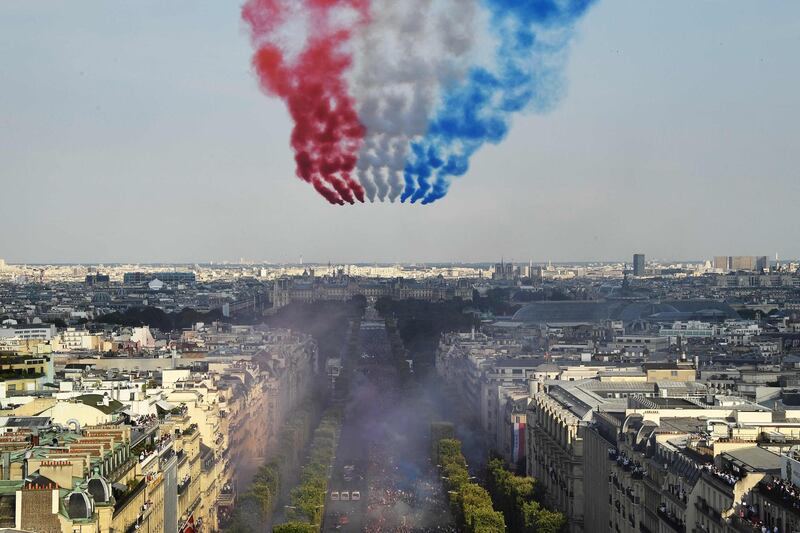 The Patrouille de France jets perform as they trail smoke in the colours of the national flag fly over the Champs Elysee as supporters welcome players of the French national football team after they won the Russia 2018 World Cup final football match in Paris.  AFP / Bertrand GUAY