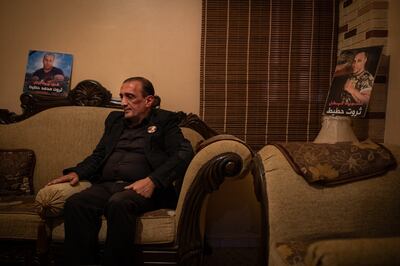 LEBANON: Monday 13 December 2021 Ibrahim Hoteit sits flanked by photos of his brother in his living room in Borj El Brajneh in the souther suburbs of Beirut.     Oliver Marsden for The National 