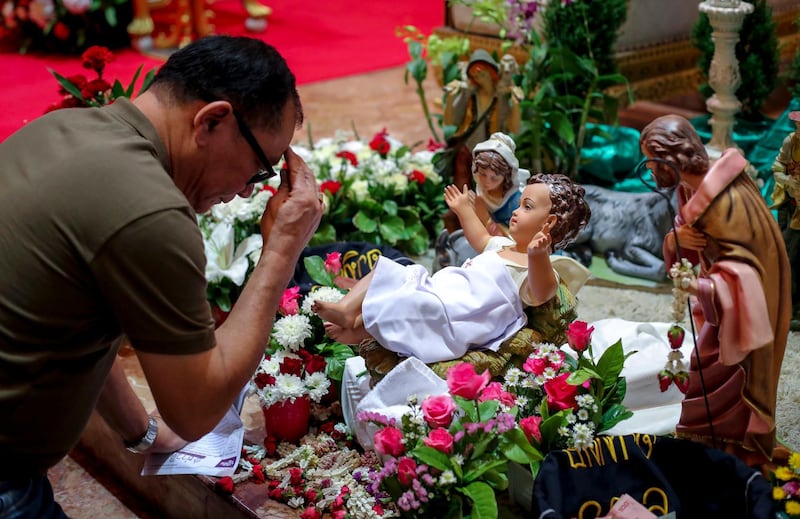 Thai Christians pray to the baby Jesus doll part of a Nativity scene during a Christmas day mass, at a church in Bangkok, Thailand.  EPA/DIEGO AZUBEL