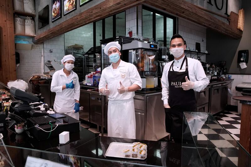 Abu Dhabi, United Arab Emirates, May 9, 2020.  Yas Mall, Abu Dhabi will be open from noon to 9pm. Supermarkets and pharmacies will be open from 9am to midnight.  Paul's Cafe workers happy to be back at work after 33 days.  (L-R) Donabelle Bote, Elcon Mabarejes and Ellis Jamisola.
Victor Besa/The National
Section:  NA
Reporter: