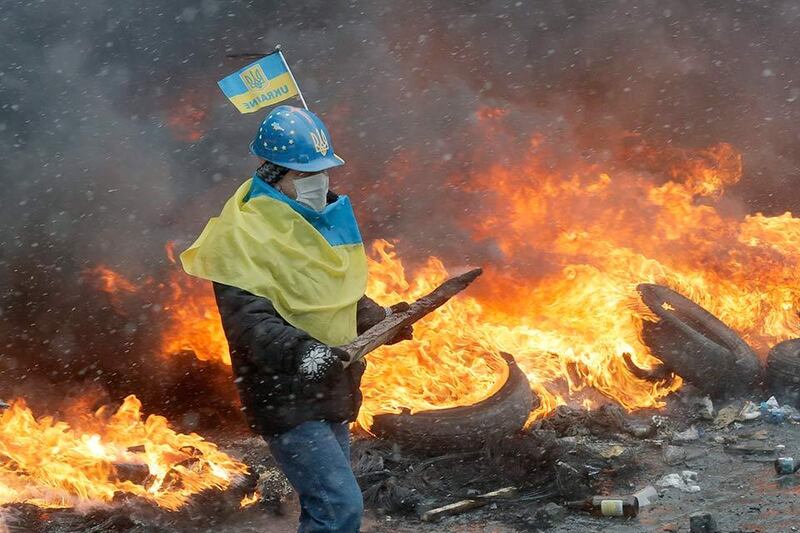 A protester in central Kiev, Ukraine, Wednesday, Jan. 22, 2014. Three people have died in clashes between protesters and police in the Ukrainian capital Wednesday, according to medics on the site, in a development that will likely escalate Ukraine's two month-long political crisis. The mass protests in the capital of Kiev erupted after Ukrainian President Viktor Yanukovych spurned a pact with the European Union in favor of close ties with Russia, which offered him a $15 billion bailout. (AP Photo/Efrem Lukatsky)