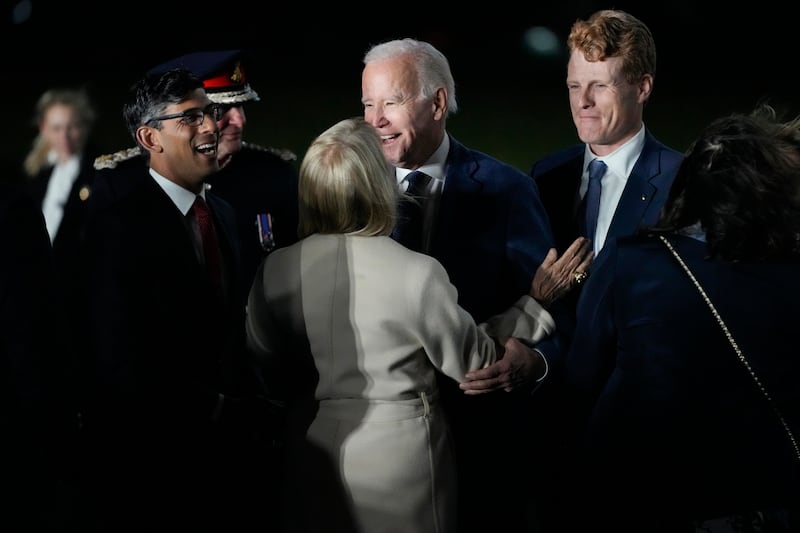 Mr Biden is greeted by Mr Sunak and US ambassador to the UK, Jane Hartley. AP