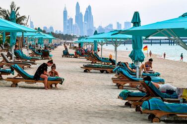 Beach-goers lie on lounge chairs by the shoreline at the Jumeirah Al Naseem, Dubai. Private beaches reopened with social distancing measures in place before public beaches. AFP 