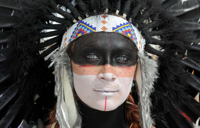 Katrina Van-Marter of Texas wears makeup and a feather headdress at the Burning Man festival in Gerlach, Nev. on Friday, Sept. 2, 2011. (AP Photo/Reno Gazette-Journal, Andy Barron) *** Local Caption ***  Burning Man Festival.JPEG-04003.jpg