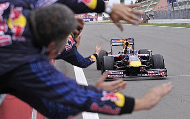 Mark Webber punches the air in front of his Red Bull mechanics after winning the German Grand Prix, the first F1 win of his career.