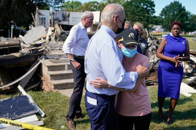 President Joe Biden talks with a person as he tours a neighborhood impacted by Hurricane Ida on September 7, 2021, in Manville, New Jersey. AP