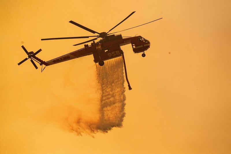 A helicopter drops water on a burning hillside during the Mendocino Complex fire near Finley, California on July 30, 2018. 
Thousands of firefighters in California made some progress against several large-scale blazes that have turned close to 200,000 acres into an ashen wasteland, destroyed expensive homes, and killed eight fire personnel and civilians in the most populous US state. The worst blaze, northern California's Carr Fire, has killed six people since Thursday, including a 70-year-old woman and her two great-grandchildren aged four and five. They perished when flames swallowed their home in Redding.
 AFP PHOTO / JOSH EDELSON