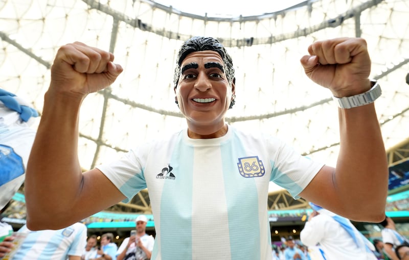 An Argentina fan wearing a Diego Maradona mask in the stands before the game. PA