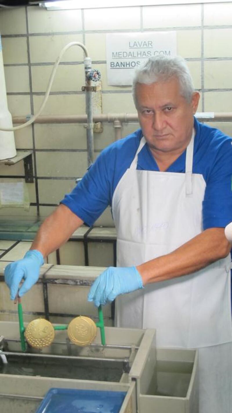 Idelberto Marinho do Rosario removes two gold medals from the electroplating tank. When they entered the solution, they were silver in colour. Gary Meenaghan for The National