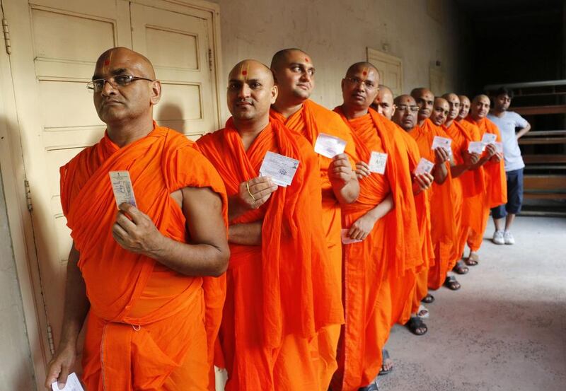 Hindu saints stand in line to cast their votes at a polling station in the western Indian city of Ahmedabad. Reuters