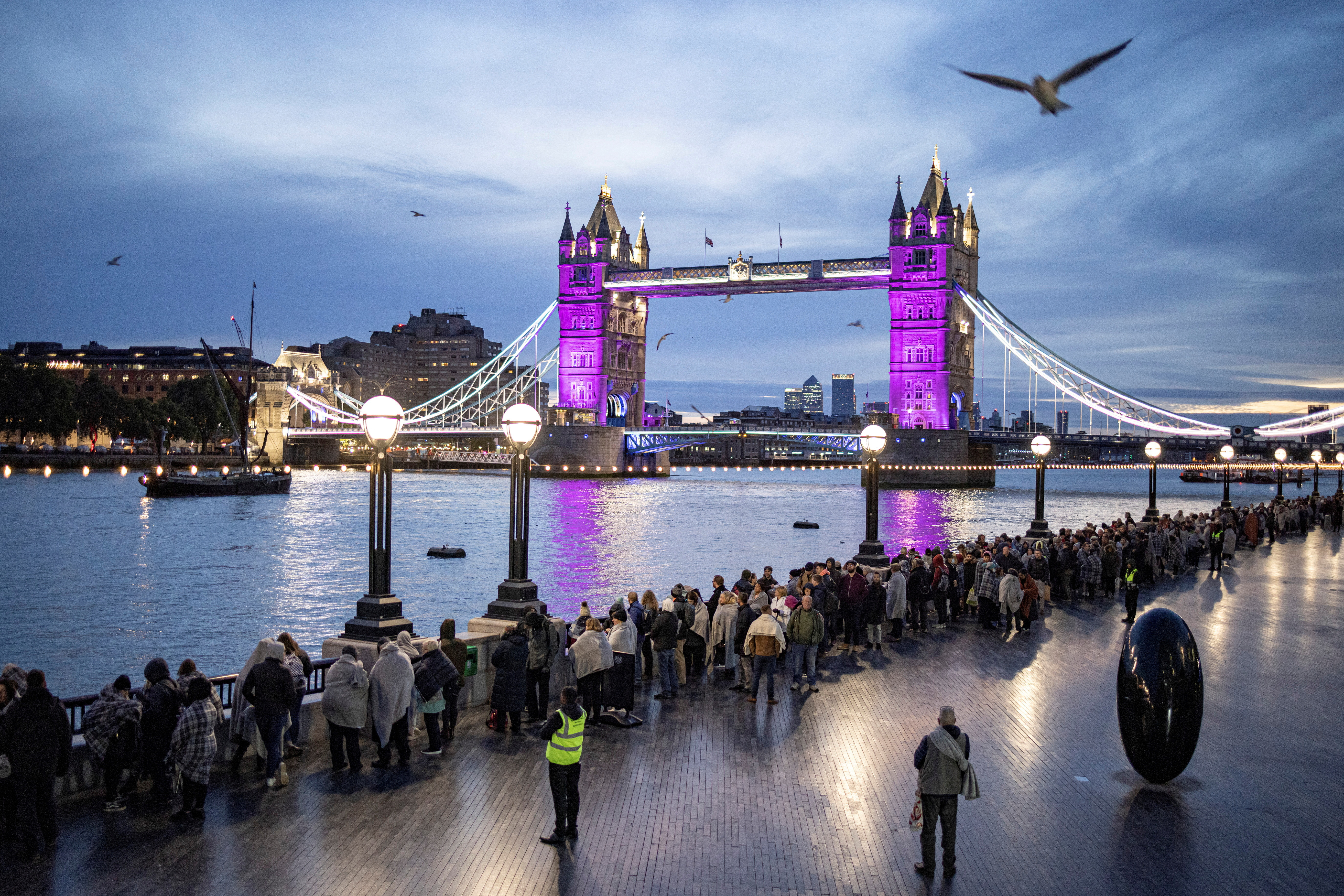 People queue along the bank of the Thames in London to pay their respects to Britain's Queen Elizabeth II. Reuters