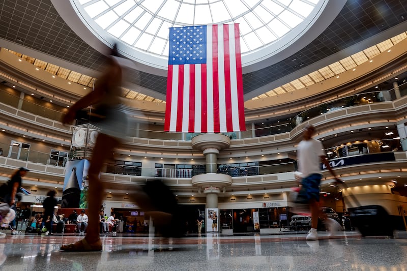 A US flag hangs in the main atrium as passengers navigate through the Fourth Of July holiday travel rush at Hartsfield-Jackson Atlanta International Airport in Georgia. EPA