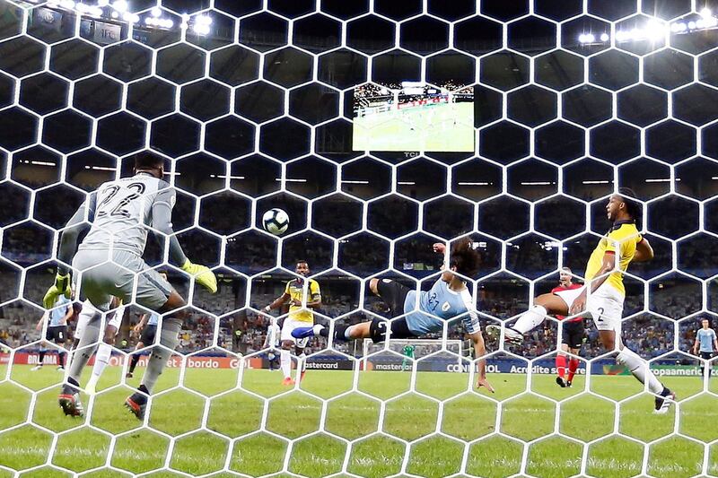 Edinson Cavani of Uruguay scores against Ecuadorian goalkeeper Alexander Dominguez during the Copa America match at Mineirao Stadium in Bello Horizonte, Brazil.  EPA