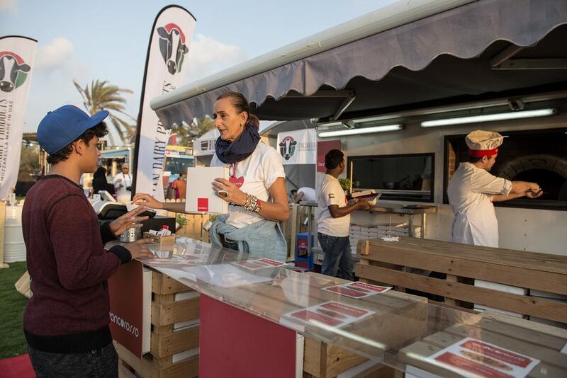 Ms.Cinzia Gambibi, the owner of Biancorosso, an authentic Italian pizza truck, serves a customer. Vidhyaa for The National