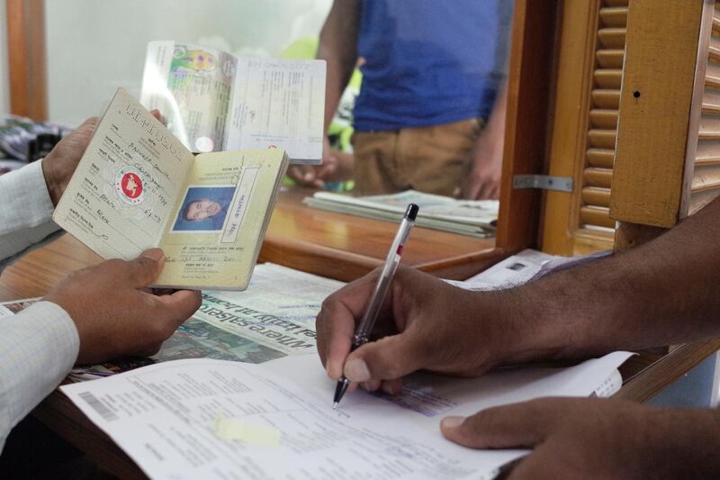 ABU DHABI, UNITED ARAB EMIRATES - - -  October 29, 2015 --- Bangladeshis get their old passports cancelled and new ones issued at the Bangledesh embassy in Abu Dhabi on Thursday, October 29, 2015. More than 50,000 Bangladeshis have yet to convert their old handwritten passports with the machine readable digital passports in the UAE. The international deadline for replacing the old passport document ends on November 24, 2015.     ( DELORES JOHNSON / The National ) *** Local Caption ***  DJ-291015-NA-Passports-006.jpg