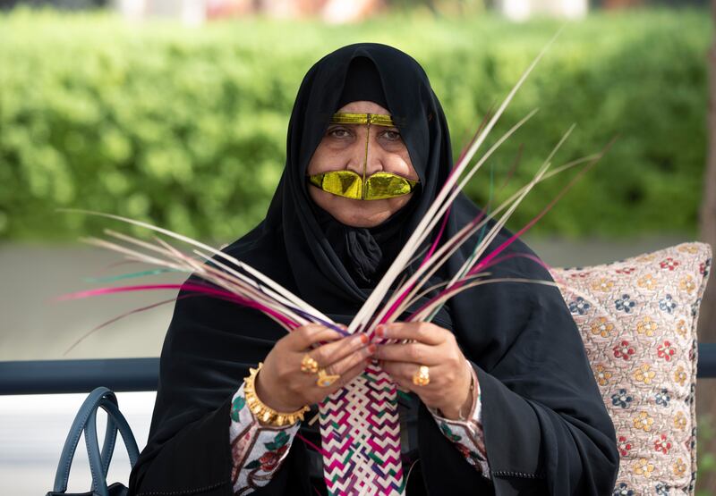 Um Muhammad demonstrates how she weaves palms leaves and wicker to create her handicrafts.