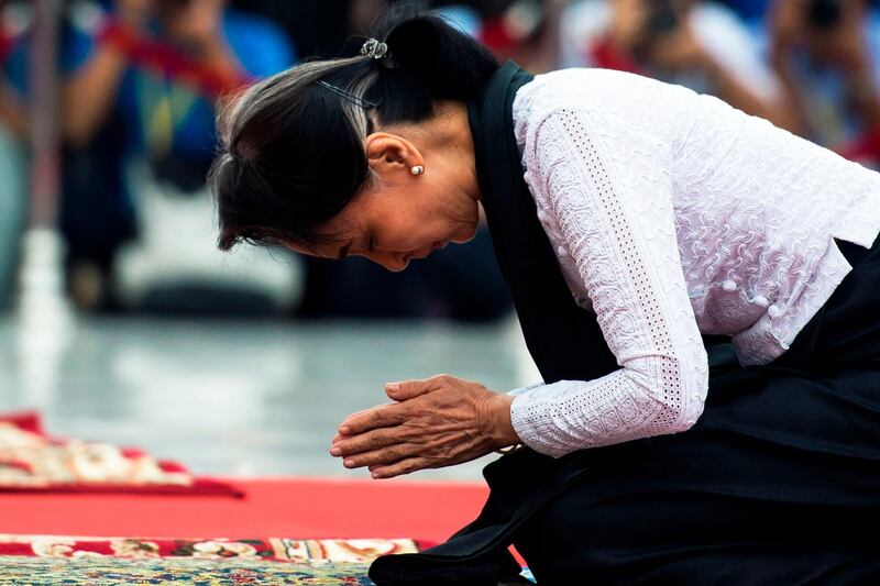 (FILES) This file photo taken on July 19, 2018 shows Myanmar State Counsellor Aung San Suu Kyi paying respects to her late father during ceremony marking the 71st anniversary of Martyrs' Day in Yangon. Amnesty International on November 13 stripped Aung San Suu Kyi of its highest honour over the de facto Myanmar leader's "indifference" to the atrocities committed by the military against Rohingya Muslims. / AFP / YE AUNG THU
