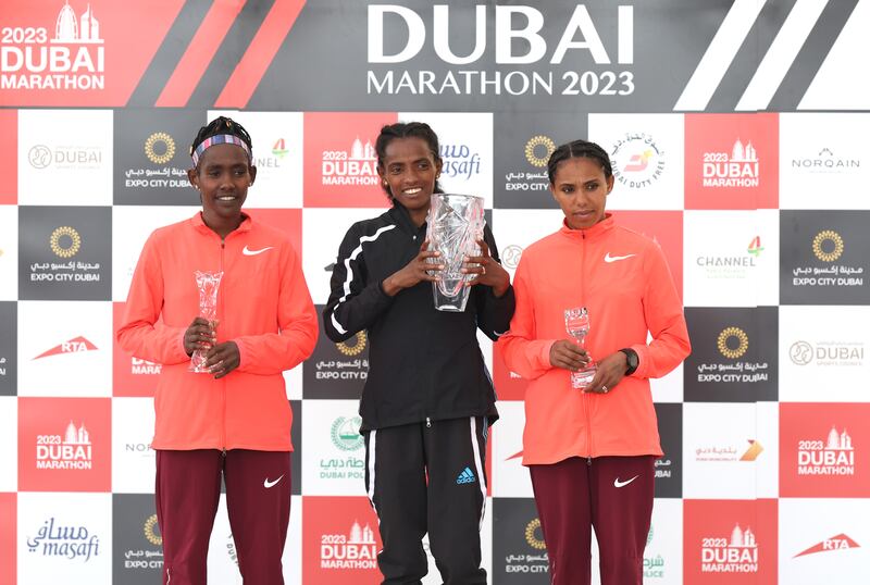 From left to right: Ruti Aga Sora, Dera Dida and Siranesh Yirga Dagne celebrate on the podium after the Dubai Marathon 2023 at Expo City on February 12, 2023. Getty