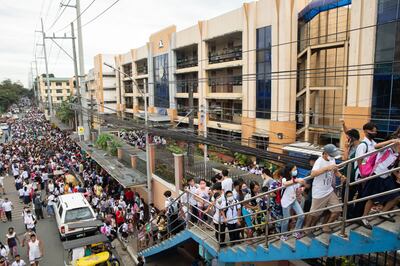 Students walk on an overpass outside an elementary school in Quezon city in the Philippines on Monday. Bloomberg