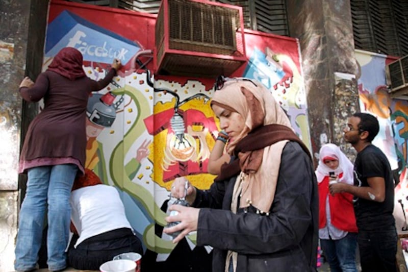 Art students from the University of Helwan decorate the walls of the arts academy with murals commemorating the revolution that overthrew Hosni Mubarak in the Zamalek neighborhood of Cairo, Egypt, Wednesday, March 30, 2011. They painted icons of the protests that began Jan. 25, including Facebook, which activists used to organize protests, and symbols of Muslim-Christian unity. (AP Photo/Manoocher Deghati)