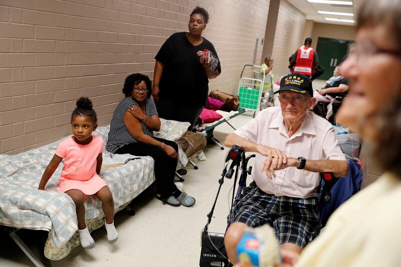 Korea war veteran, Ed Coddington, 83 waits with Markia McCleod, her aunt Ernestine McCleod and daughter Keymoni, 4, in a shelter for Hurricane Florence to pass after evacuating from their nearby homes in Conway, South Carolina. AP Photo