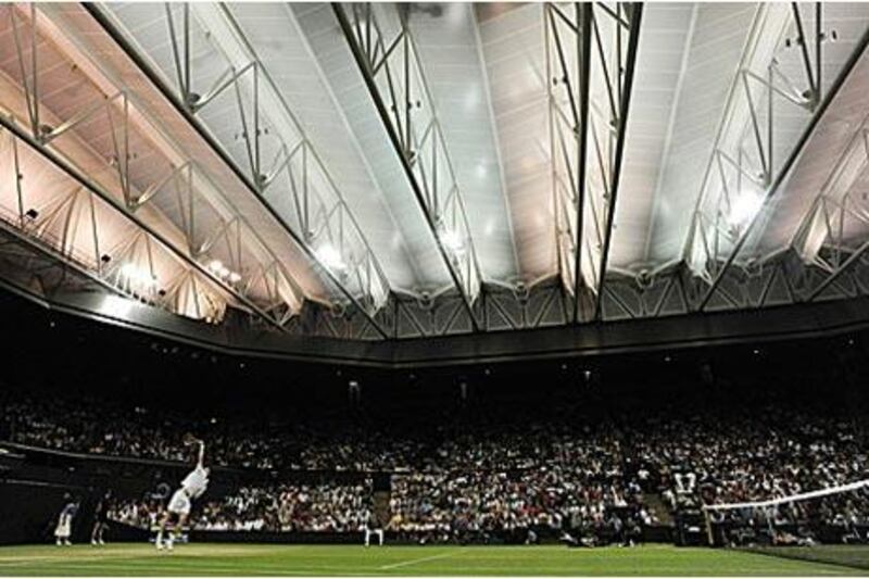 Andy Murray serves to Stanislas Wawrinka during their fourth-round match at Wimbledon. It was the first competitive game at the tournament to be played undercover.