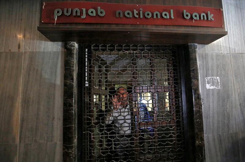 A Central Bureau of Investigation (CBI) official looks out from a closed door of a Punjab National Bank branch in Mumbai, India, February 19, 2018. REUTERS/Francis Mascarenhas