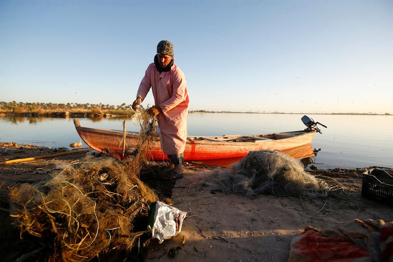 A fisherman sorts fishing nets on the shore of the Najaf Sea, a lake and marshy area near the city of Najaf. Reuters