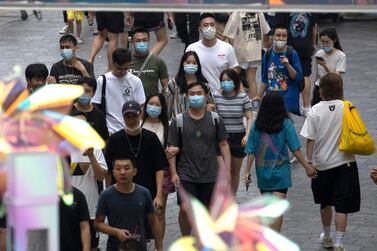Shoppers wearing masks to curb the spread of the coronavirus walk through a mall district in Beijing. China's economy continued to recover on the back of strong services as the government eases virus control measures. AP
