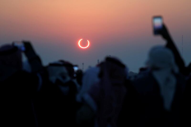 People take photos with their smartphones as they monitor the annular solar eclipse on Jabal Arba (Four Mountains) in Hofuf, in the Eastern Province of Saudi Arabia. REUTERS