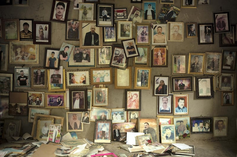 In this Sept. 12, 2019, photo, pictures of Yazidis slain in 2014 by Islamic State militants are found in a small room at the Lalish shrine in northern Iraq. When Yazidis were seized alive by the militants, top commanders registered them, photographed the women and children, categorized them into married, unmarried and girls, and decided where they would be sent. Initially, the thousands of captured women and children were handed out as gifts to fighters who took part in the Sinjar offensive, in line with the group’s policy on the “spoils of war.” (AP Photo/Maya Alleruzzo)