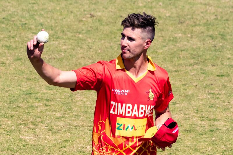 Zimbabwe's Brad Evans raises the ball after taking five wickets in the innings. AFP