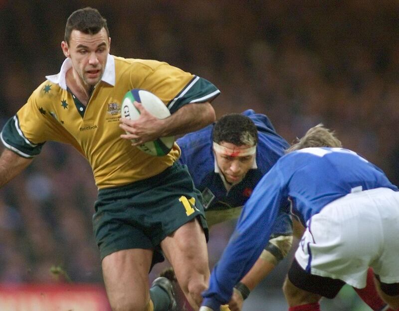 Australian winger Joe Roff (L) is tackled by French lock Abdelatif Benazzi (C) and French winger Philippe Bernat-Salles (R) during the Rugby World Cup 1999 final game opposing France to Australia 06 November 1999 at the Millennium Stadium in Cardiff. (ELECTRONIC IMAGE)  / AFP PHOTO / OLIVIER MORIN