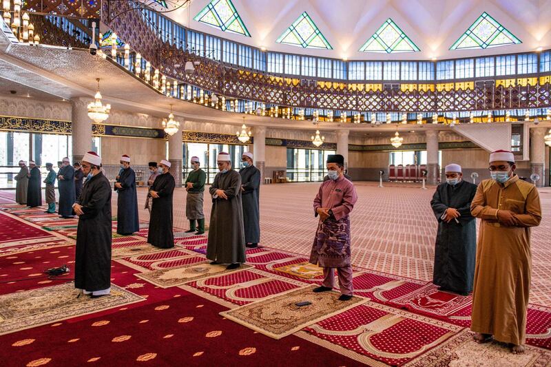 Mosque staff offer Friday prayers, while practicing social distancing in Kuala Lumpur.  AFP