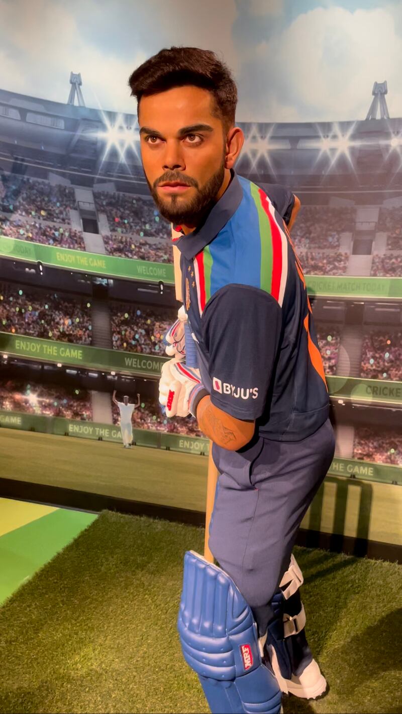 Indian cricketer Virat Kohli holds up a bat at Madame Tussauds Dubai