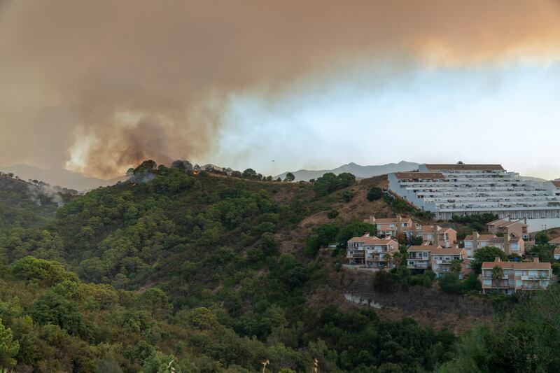 The wildfire burns near homes in Estepona. EPA