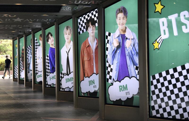 A man walks past commercial posters showing K-pop group BTS members outside a duty free shop in Seoul on September 1, 2020. - K-pop sensation BTS has become the first all-South Korean act to rule the top US singles chart, industry tracker Billboard announced on August 31, with their English-language "Dynamite" hitting number one. (Photo by Jung Yeon-je / AFP)