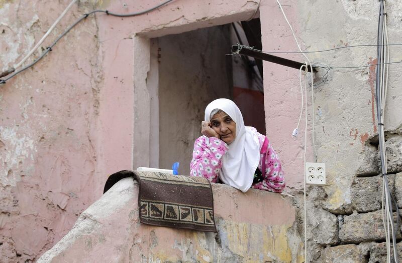 A Lebanese woman sits at her home's entrance during confinement due to the COVID-19 pandemic, in the historic part of the southern coastal city of Saida. Lebanon's President called on international donors to provide financial assistance to the crisis-hit country as it grapples with a severe economic downturn compounded by the novel coronavirus pandemic. AFP