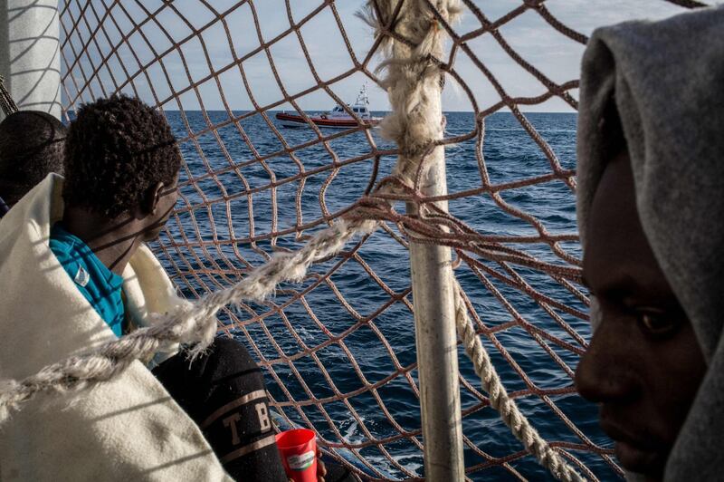 Migrants watch a vessel of the Italian coast guards from the Dutch-flagged rescue ship Sea Watch 3, as 47 migrants including minors, are stranded aboard the vessel anchored off Syracuse, Sicily. . Save the Children appealed to Italy to allow minors rescued in the Mediterranean to land.   AFP
