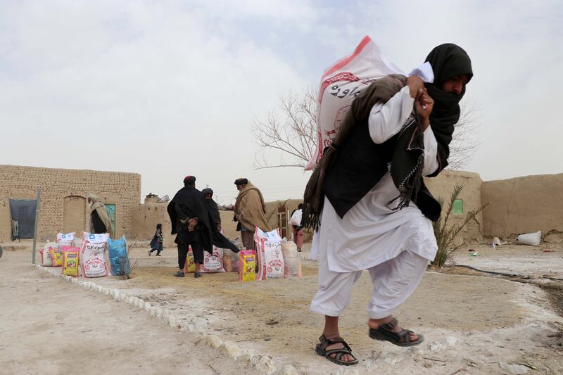 People receive food distributed by the Afghan Charity Foundation in Kandahar, Afghanistan. EPA